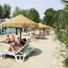 Persone rilassate su lettini sotto ombrelloni in spiaggia.
