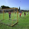 Bambini giocano a calcio su un campo erboso.
