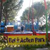 Trampolini con bungee in un parco, molte persone.