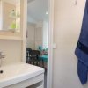 Lavabo con specchio e asciugamano blu appeso.