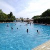 Piscina all'aperto con persone che nuotano.