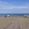 Spiaggia con bagnanti e ombrelloni colorati.