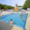 Piscina con giochi d'acqua e bambini che nuotano.
