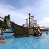 Piscina con grande nave pirata e bagnanti.