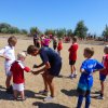 Allenatore insegna calcio a bambini su sabbia.