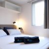 Letto matrimoniale con due cuscini e luce soffusa.