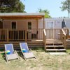 Mobile home con veranda e sedie a sdraio.