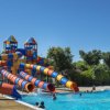 Piscina con scivoli colorati e persone.