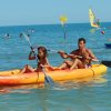 Uomo e bambina su un kayak nel mare.