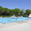 Piscina con giochi d'acqua e persone che nuotano.