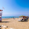 Spiaggia con ombrelloni colorati e torretta di salvataggio.