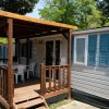 Casa mobile con veranda in legno e sedie bianche.