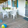 Veranda con tavolo e sedie bianche.