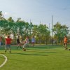 Ragazzi giocano a calcio su un campo all'aperto.