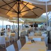 Tavoli apparecchiati con ombrelloni in un ristorante all'aperto.