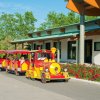Trenino turistico rosso gira sulla strada.