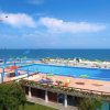 Piscina con vista mare e colorati ombrelloni.