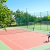 Campo da tennis all'aperto, giocatore in azione.