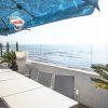 Tavoli all'aperto con ombrelloni sul mare.