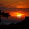 Tramonto arancione sul mare con nuvole.