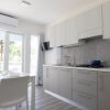 Cucina moderna con tavolo bianco e porta finestra.