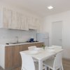 Cucina piccola con tavolo bianco e mobili in legno.