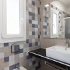 Bagno con lavabo rettangolare e piastrelle quadrate colorate.