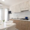 Cucina moderna con tavolo da pranzo e sedie bianche.