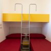 Due letti singoli con scala e armadietto giallo.