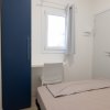 Armadio blu, scrivania con sedia e finestra.