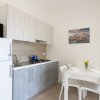 Cucina moderna con tavolo da pranzo e sedie bianche.