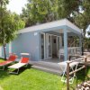 Bungalow blu con sedie a sdraio arancioni.