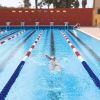 Persona che nuota in una piscina a corsie.