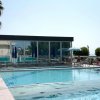 Piscina all'aperto con lettini e ombrelloni.