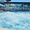 Piscina con idromassaggio e ombrelloni azzurri.
