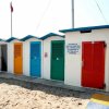 Cabine colorate sulla spiaggia sabbiosa.
