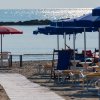 Ombrelloni blu e rossi su una spiaggia sabbiosa.