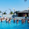 Persone in piscina partecipano ad attività acquatiche.
