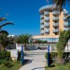 Hotel con balconi e palme sotto un cielo blu.