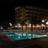 Piscina illuminata di notte davanti all'hotel.