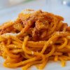 Piatto di spaghetti al pomodoro con formaggio grattugiato.