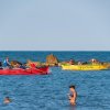 Barche in mare con persone che nuotano.