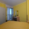 Camera gialla con balcone e scrivania.
