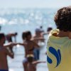 Giovani sulla spiaggia mentre fanno esercizi guidati.
