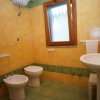 Bagno con piastrelle gialle e verdi, bidet e lavabo.