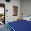 Camera da letto con letto blu e terrazza con vista mare.
