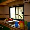 Cucina con lavello e bicchieri colorati.