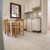 Cucina con tavolo e sedie, vista su bagno.