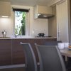 Cucina moderna con mobili in legno e tavolo apparecchiato.