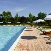 Piscina all'aperto con ombrelloni bianchi.